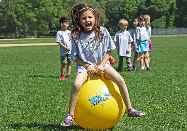 Poly Prep student playing on a bouncy ball